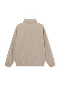 Giacca beige leggera con colletto alto, polsini elasticizzati e orlo arricciato. Texture liscia, design minimalista, senza chiusure visibili.