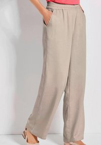 Lichtbeige, wijde broek met een elastische tailleband en zijzakken, gemaakt van een gestructureerde stof, met een losse pasvorm en rechte snit.