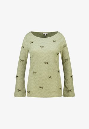 Lichtgroen shirt met lange mouwen en een subtiele textuur, versierd met kleine donkergroene strikjes verspreid over de voorkant en mouwen.