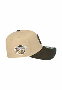Beige Kappe mit einem dunkelgrünen Schirm, versehen mit einem gestickten Totenkopf-Logo und "World Series 98". Aus Baumwolle mit strukturiertem Design.