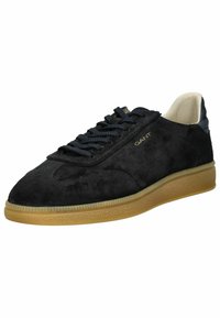 Schwarze Wildleder-Sneaker mit runder Zehenpartie, kontrastierender Gummisohle in Karamellfarbe und blauen Schnürsenkeln. Verfügt über dezentes Branding in Gold.