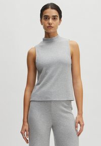Grijs geribd mouwloos topje met een hoge hals, met een iets losse pasvorm die tot de taille valt, gecombineerd met bijpassende geribde broek.