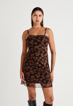 Rochie neagră din mătase cu decolteu volan, prezentând un model floral de trandafiri în tonuri de maro. Bretele subțiri și un design lejer, fluid.