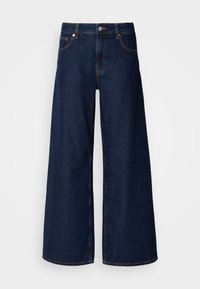 Jean denim bleu foncé à jambes larges avec bouton sur le devant, fermeture éclair, et coutures de style cinq poches.