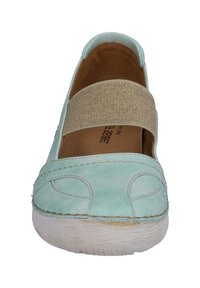 Ljusblå mocka lågskor med elastisk rem, rund tå, vit gummisul och subtila sömnadsdetaljer. Inuti finns en beige innersula.