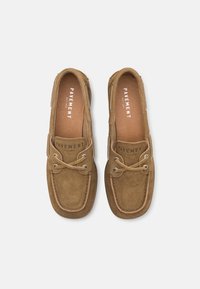 Chaussures de bateau en suede marron avec un bout arrondi, des accents en cuir, des coutures beiges et un design à lacets avec des œillets en métal.