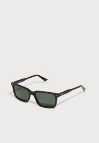 Occhiali da sole quadrati con motivo tartarugato, lenti verde scuro e montatura in plastica nera. Presentano il marchio Polaroid sulle astine.