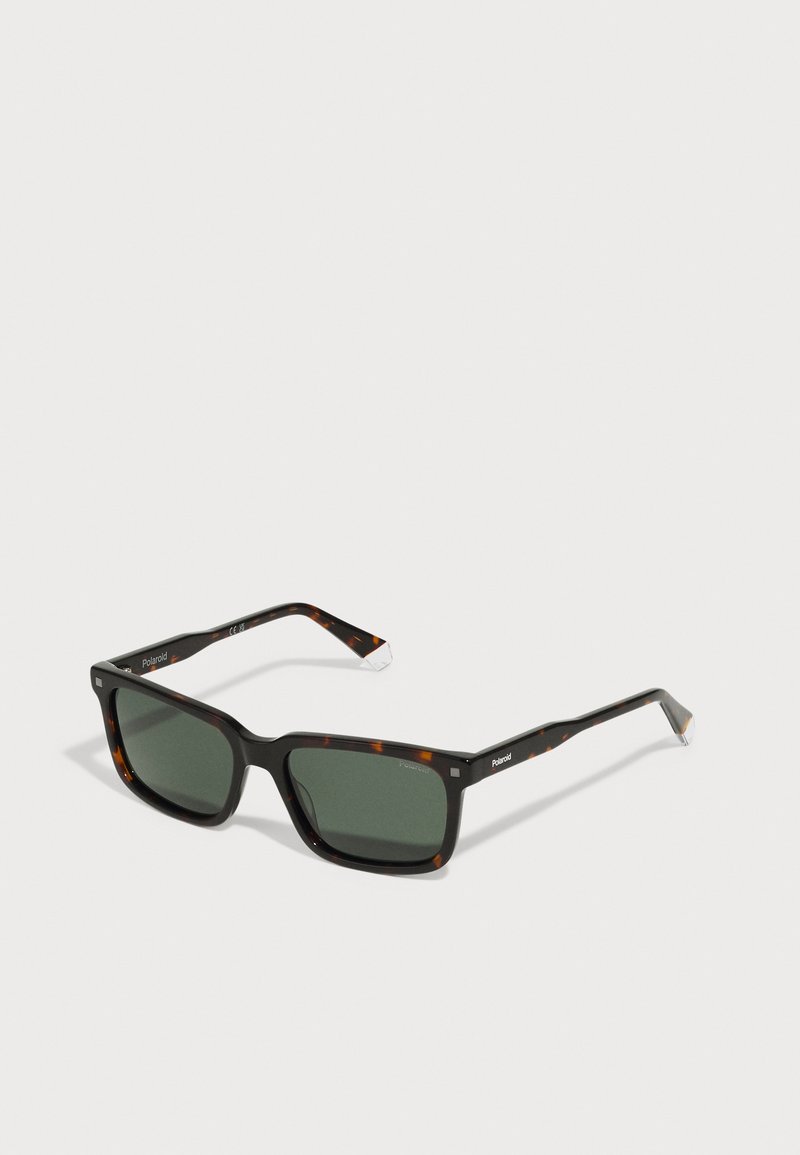 Occhiali da sole quadrati con motivo tartarugato, lenti verde scuro e montatura in plastica nera. Presentano il marchio Polaroid sulle astine.