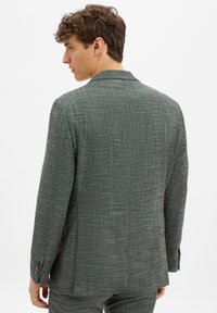 Helles graues Textur-Anzugjackett mit einem Reverskragen, einem einzelnen Schlitz und drei Knopfakzenten an den Ärmeln.