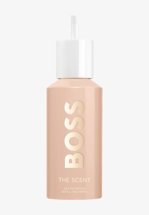 Beige Spray-Nachfüllflasche mit weißem Verschluss, beschriftet mit „BOSS THE SCENT Eau de parfum refill/recharge“ auf einfachem Hintergrund.