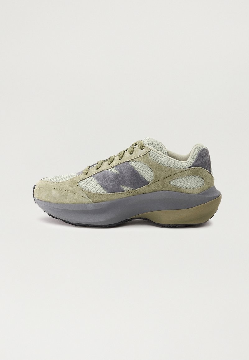 Sneaker en daim et mesh vert clair et gris avec une semelle épaisse grise et un design à lacets, présenté en profil latéral sur fond blanc.