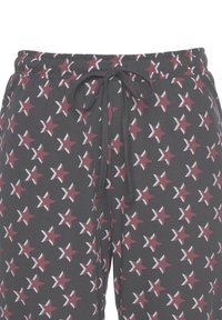 Gray pajama pants with an elastic waistband and drawstring, featuring a repeating pattern of red and white stars. Soft, lightweight fabric.