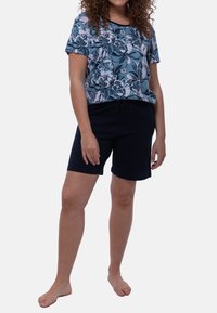 Top floreale a maniche corte in blu e bianco con pantaloni corti navy a vita elastica. Il top presenta un collo rotondo e una vestibilità comoda.