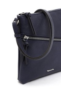 Navy Lederhandtasche mit strukturierter Oberfläche, einer Reißverschlusstasche auf der Vorderseite und einem einzelnen abnehmbaren Tragegurt. Silbern Logo-Detail.