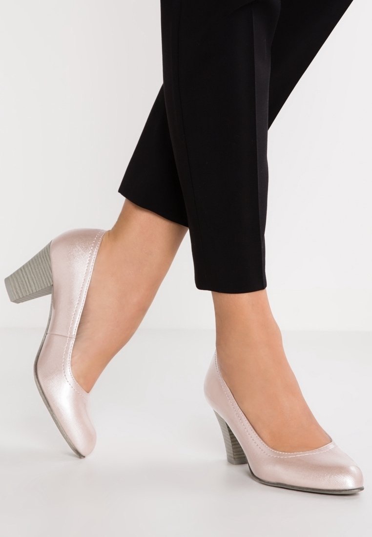 Vaaleanpunaiset nahka korkokengät, joissa on pyöreä kärki ja teksturoitu harmaa korko, valkoista taustaa vasten.