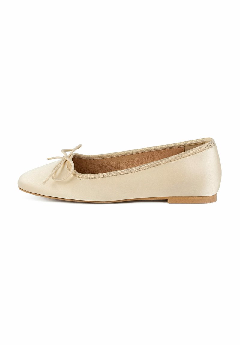 Ballerines en satin beige avec un bout arrondi, présentant un petit nœud et une semelle plate. Texture lisse et design minimaliste.