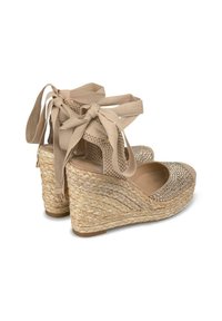 Sandali beige con zeppa e piattaforma in paglia intrecciata, dotati di una parte superiore testurizzata e fasce di tessuto annodate, decorate con strass nell'area delle dita.