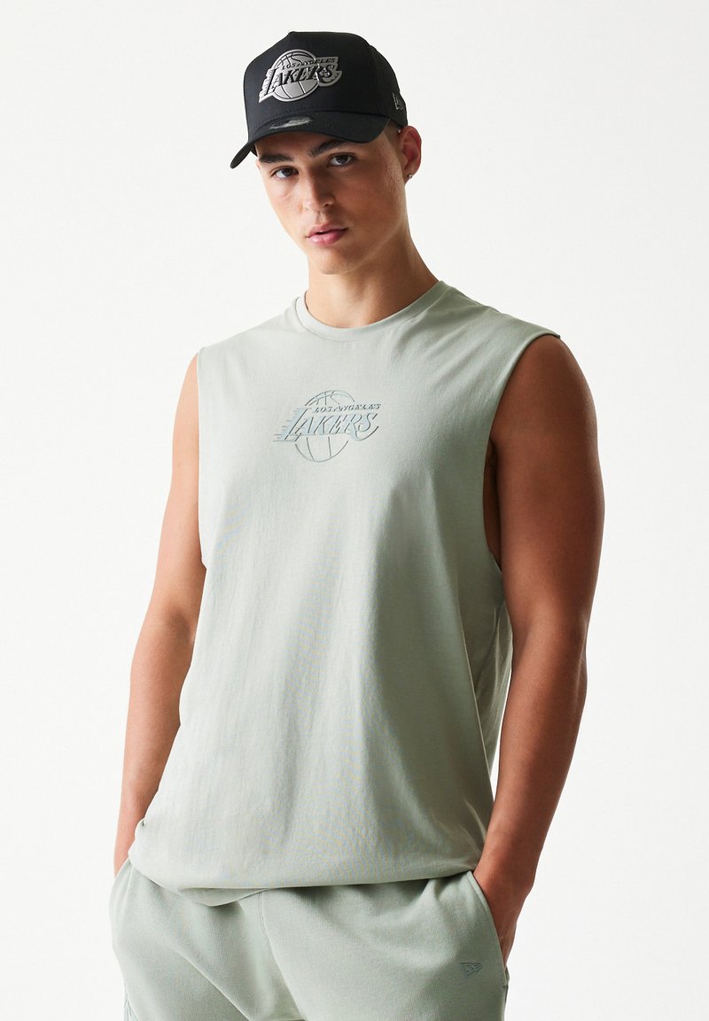 Αμάνικο πουκάμισο ανοιχτού πράσινου χρώματος από απαλό ύφασμα, με διακριτικό γραφικό μπάσκετ και την επιγραφή "LAKERS". Μαύρο καπέλο μπέιζμπολ με λογότυπο.