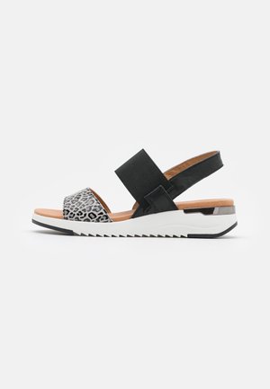 Black and gray leopard print sandal with a thick elastic strap, a textured footbed, and a white serrated sole for grip and support.