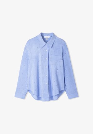 Camicia azzurra chiaro con bottoni, a righe verticali bianche e un sottile dettaglio a motivo. Presenta un colletto, maniche lunghe e una tasca sul petto.