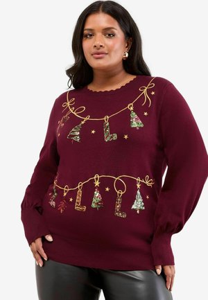 Pull en bourgogne à manches longues, avec un col festonné, présentant des embellissements festifs tels que des arbres et des lettres en sequins accompagnés d'un design en ruban doré.