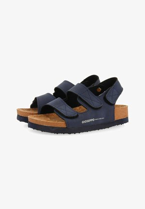 Sandalias azul oscuro con correas ajustables de Velcro, plantilla de corcho y suela texturizada negra. Destacan con la marca "GIOSEPPO".
