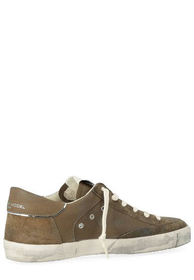 Bruine leren en suède sneakers met witte accenten, platte veterstrik en een versleten zool. Beschikt over ronde gaten en een metalen hiel detail.