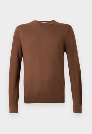 Hnedý dlhý rukáv crewneck sveter s ribovanými manžetami a lemom, vystavený na jednoduchom svetlošedom pozadí.