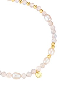 Ogrlica iz biserov, ki vsebuje okrogle in ovalne bele bisere, prozorne teksturirane perle in zlate akcentne elemente. Vsebuje majhno oznako z logotipom.