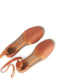 Pomarańczowe zamszowe espadryle z plecionymi jutikowymi podeszwami i dopasowanymi zapięciami na kostkę. Okrąły czubek i gładka faktura z widocznymi akcentami szwów.