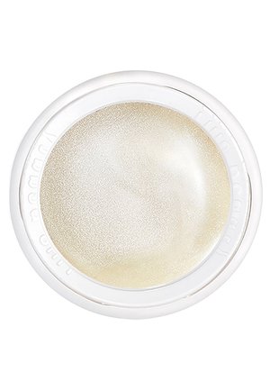 Lentille de contact ronde beige translucide dans un boîtier en plastique blanc vue de dessus sur fond blanc.