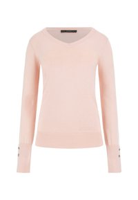 Jasnoróżowy sweter z długim rękawem w serek, z ribbowanymi mankietami i dołem. Ozdobiony dwoma małymi guzikami na każdym mankiecie oraz logo GUESS na dole.