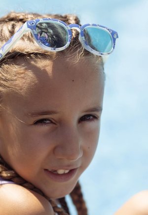 Occhiali da sole con montatura blu e dettagli caratteriali, lenti riflettenti, un design testurizzato e un'acconciatura intrecciata su uno sfondo chiaro.