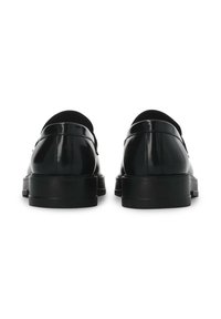 Pantofi din piele patentată neagră, cu un finisaj neted, profil mic, vârf rotund și talpă robustă din cauciuc negru. Vedere din spate care evidențiază designul curb.