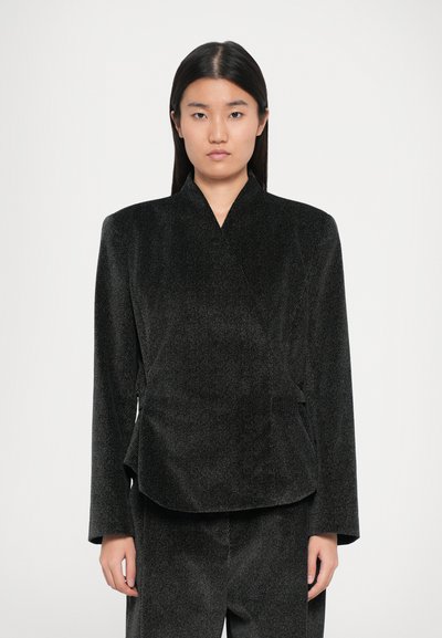 Zwarte gestructureerde blazer met een wikkelontwerp, voorzien van lange mouwen en een getailleerde silhouet. De stof heeft een subtiel streepjespatroon.