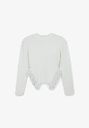 Pull en maille blanche à manches longues avec un design court, comprenant des accents de volants en dentelle le long de l'ourlet et des côtés. Texture douce sur l'ensemble.