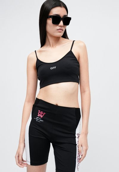Černý cropped top s logem "OFF", spárovaný s černými vysoce pasovými šortkami s červenými a bílými designovými detaily a textovými akcenty.