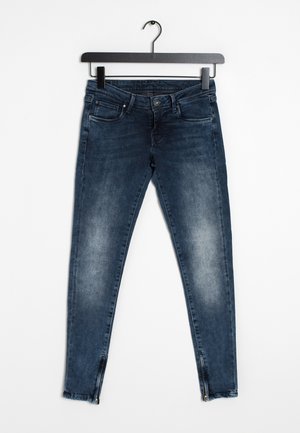 Blå denimslim jeans med en urtvättad finish, fem fickor och blixtlås vid anklarna. Materialet är mjukt med en lätt stretch.