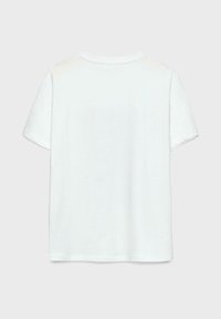 T-shirt en coton blanc avec une coupe décontractée, des manches courtes et un col rond. L'arrière est uni sans graphiques ni motifs.