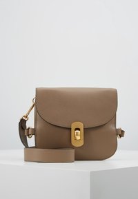 Bolso bandolera de cuero color canela con solapa redondeada, herrajes dorados y una correa desmontable. Acabado texturizado y cierre con hebilla como detalles destacados.