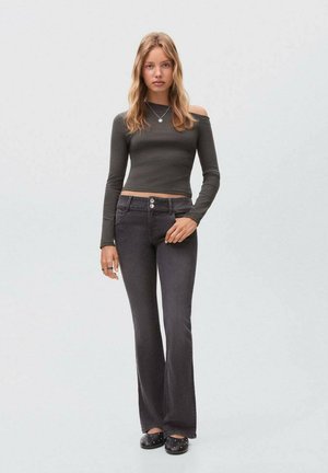 Dark grey flared jeans with a high waistband and two-button closure, paired with a fitted, off-the-shoulder long-sleeve top in olive green.