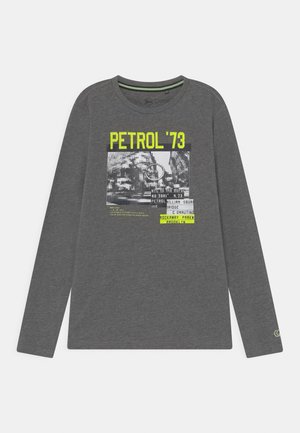 Donkergrijs shirt met lange mouwen met gele tekst "PETROL '73" en een zwart-witte afbeelding met stedelijke elementen en extra kleine tekst.