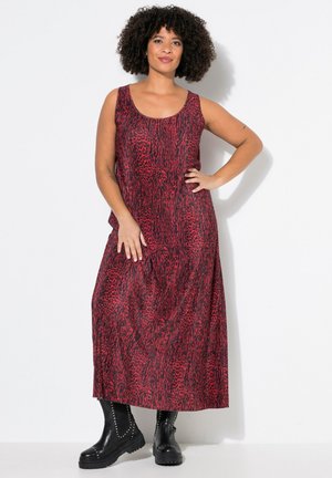 Vestido maxi sin mangas en rojo y negro con un diseño de estampado animal texturizado, combinado con botas de tobillo negras con tachuelas.