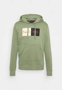 Felpa verde con cappuccio, dotata di tasca a marsupio frontale e un'etichetta rettangolare con la scritta "Originals" e "Jack & Jones" in arancione e nero.