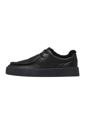 Sneaker nero basso con suola spessa, tomaia in pelle, chiusura con lacci e morbida fodera in pile visibile intorno al collo della caviglia.