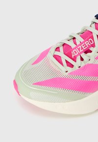 Sneaker front i hvid og pink mesh med cremefarvede snørebånd og "ADIZERO" label på tungen, fremhæver detalje og tekstur.