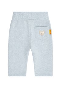 Hellgraue Baumwoll-Sweatpants mit einem elastischen Bund, ausgestattet mit einer kleinen aufgesetzten Tasche mit einer Teddybär-Stickerei und einem gelben Etikett.