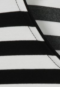 Schwarz-weißer gestreifter Stoff mit horizontalen Streifen. Glatte Textur, Baumwollmaterial. Sichtbare Nähte entlang der Kanten.