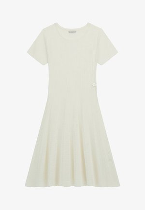 Kremowa sukienka z prążkowanej tkaniny, z krótkimi rękawami, rozkloszowanym dołem i teksturowanym materiałem. Posiada mały srebrny akcent w kształcie serca w okolicy talii.