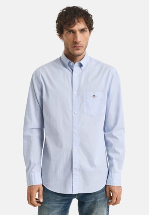 Lichtblauwe, lange mouwen button-up shirt van katoen met een kraag, borstzak en klein logodetail. G gedragen met blauwe jeans.